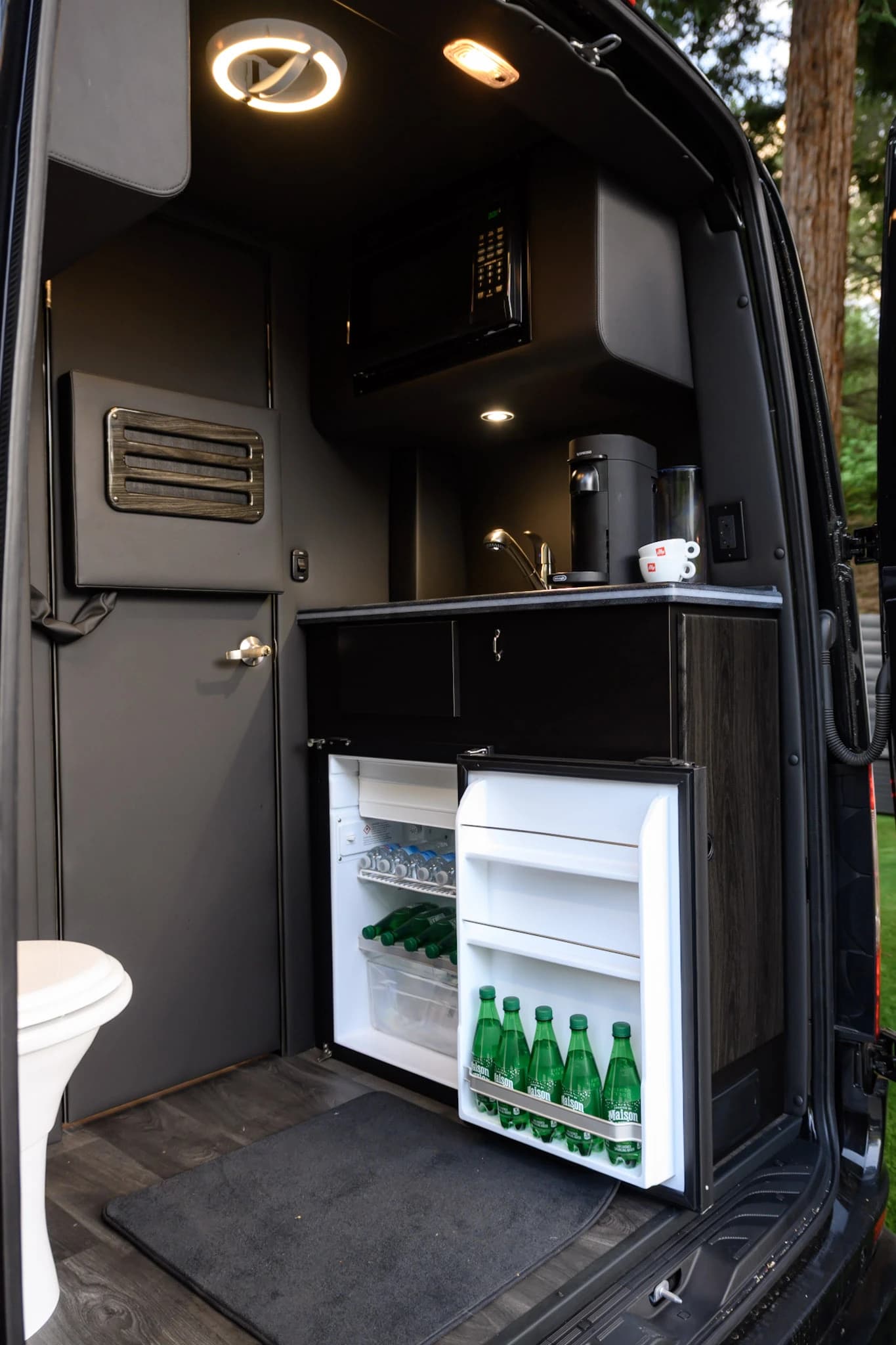 Keep wine, water, and snacks chilled in the built-in mini refrigerator — standard on Napa wine tours and long-haul private transportation.