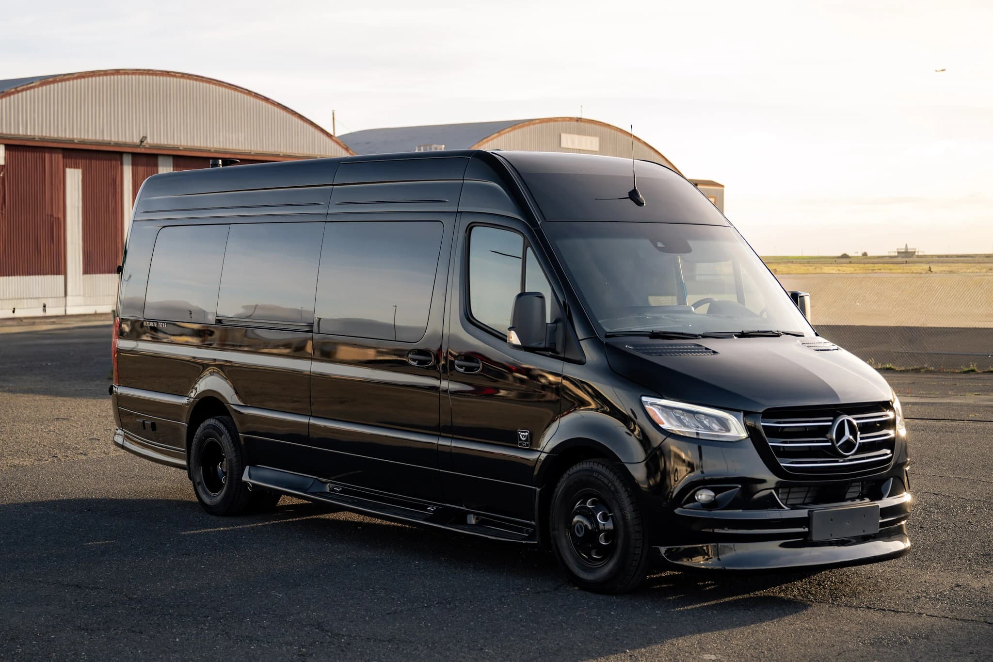 A polished black Sprinter designed for private airport transfers, corporate travel, and group transportation.