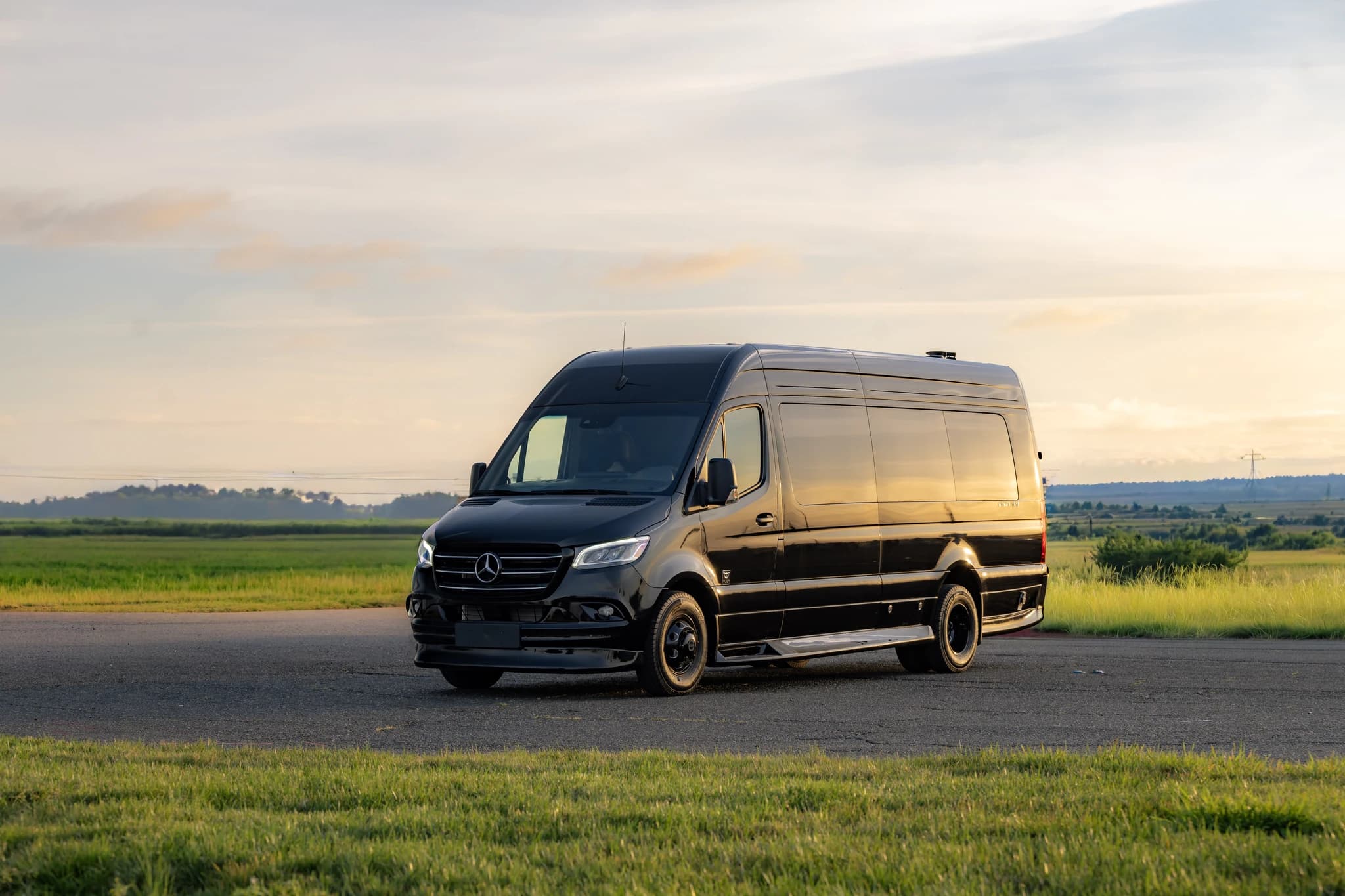 MIOR's custom black Mercedes-Benz Sprinter executive vehicle at golden hour, exterior profile